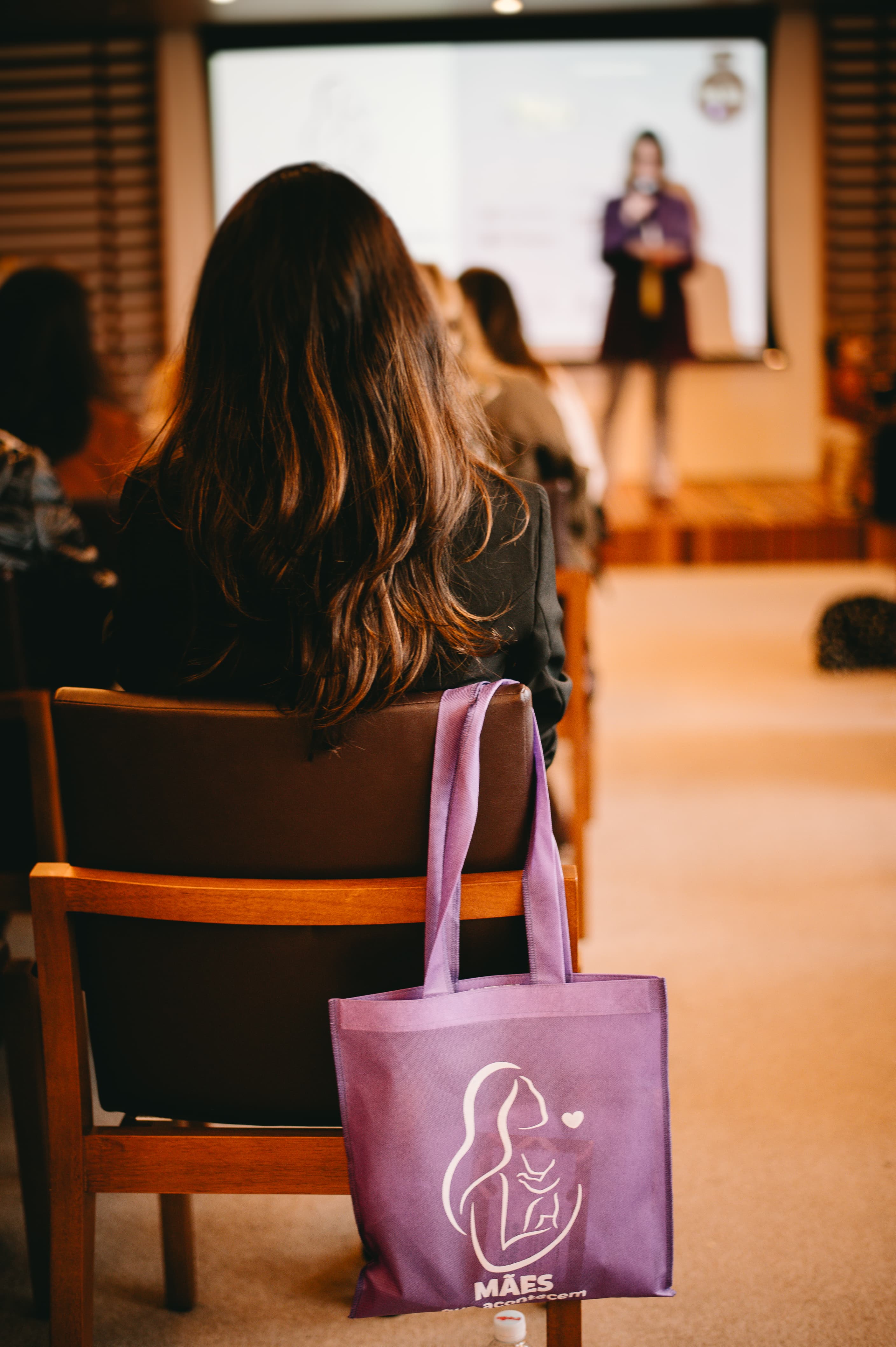 Participante com ecobag Mães que Acontecem no auditório